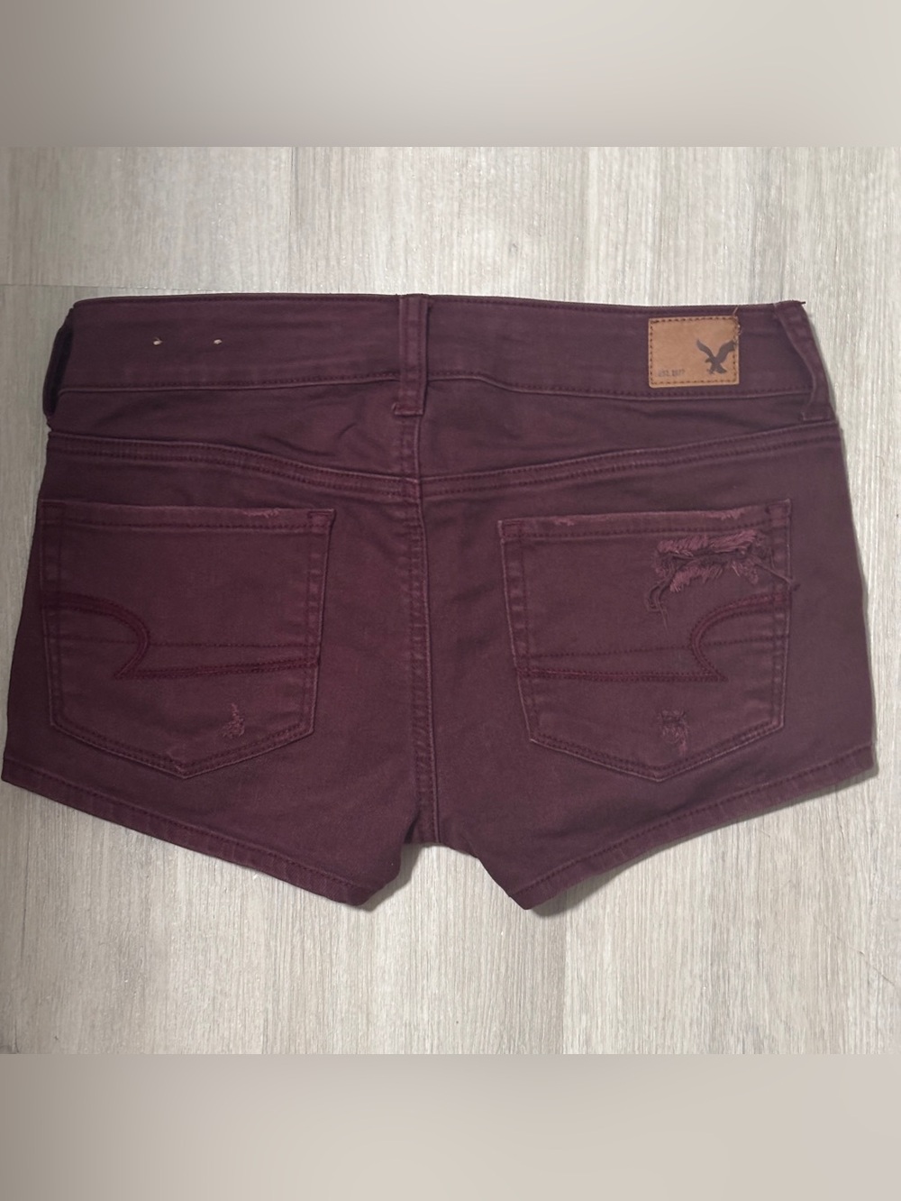 American Eagle stretch low rise distressed burgundy denim shorts size 4